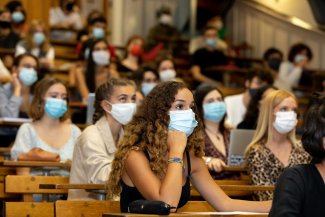 des étudiantes portant des masques chirurgicaux dans un amphitéâtre